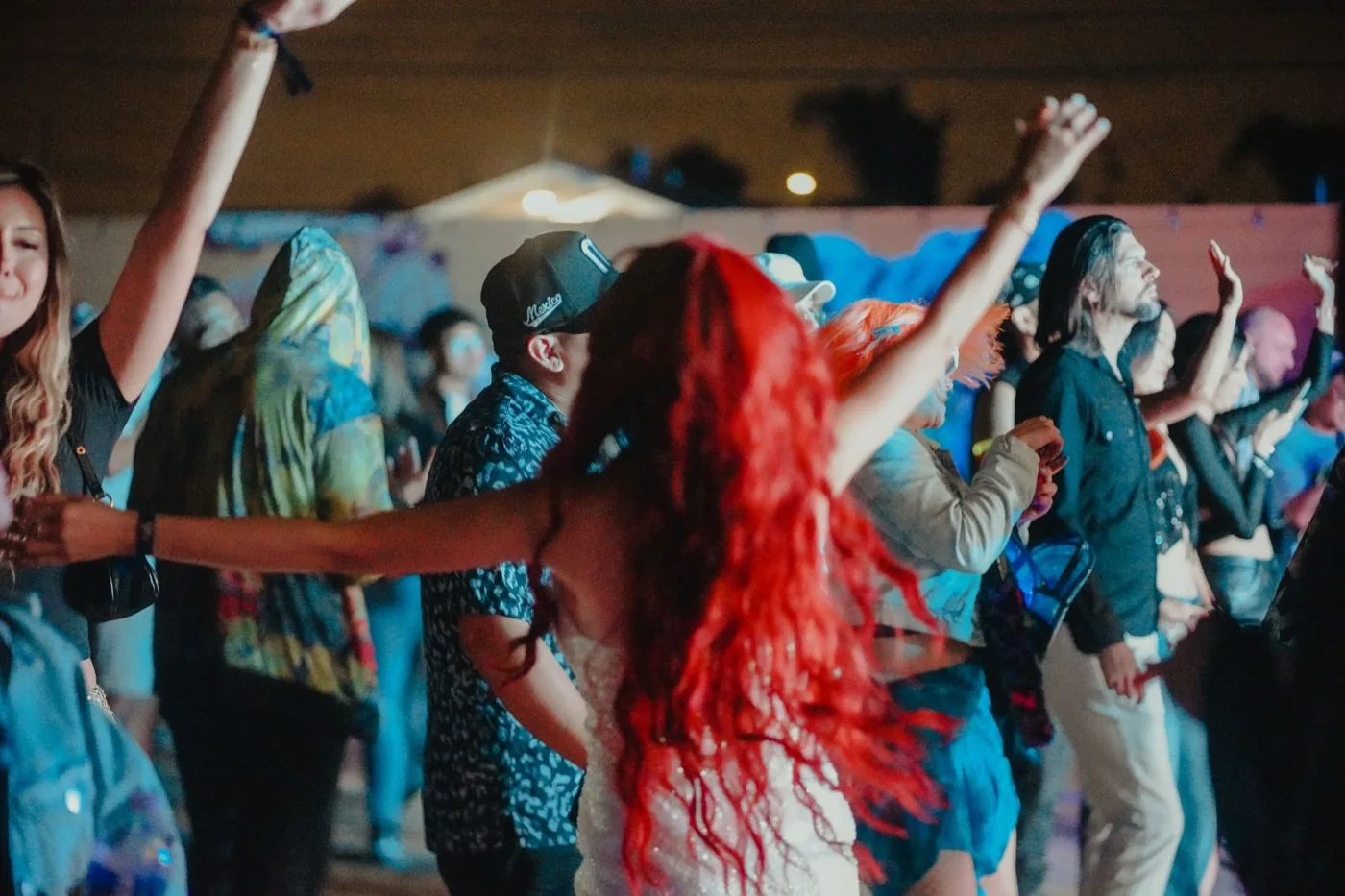 Crowd dancing at night under blue and teal stage light