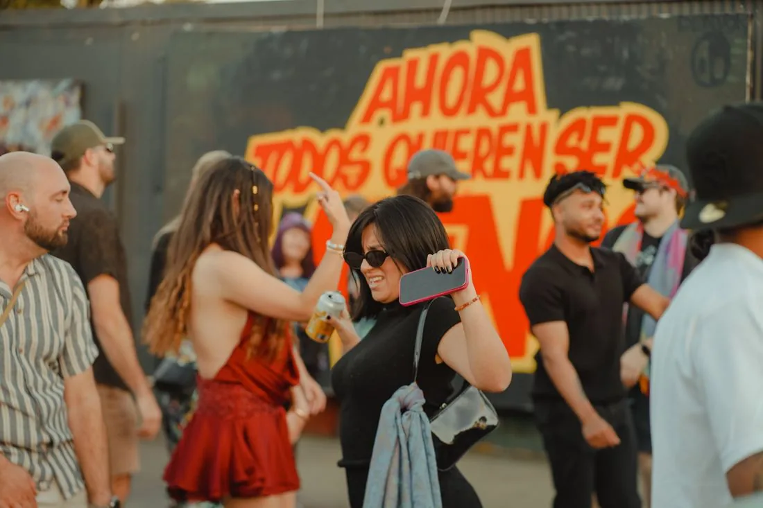 Crowd under an orange sign at the back of the yard