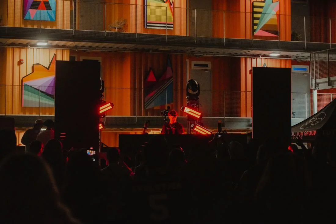 Crowd in front of the lit stage after dark