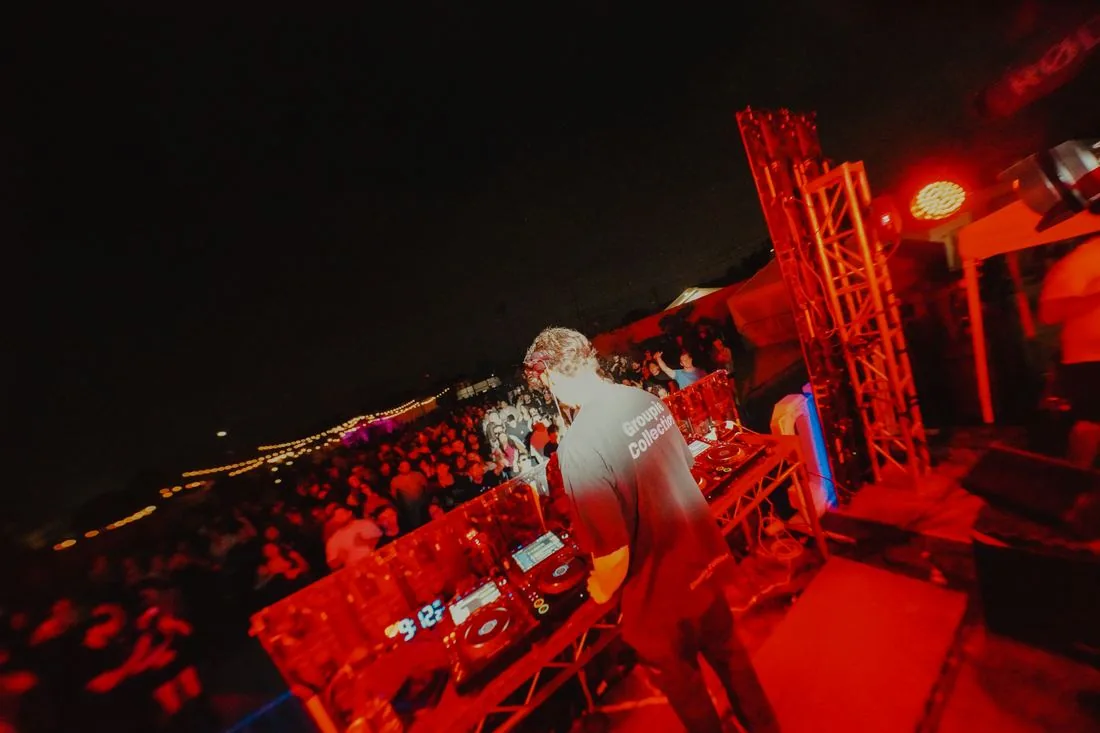 The booth from behind in red light with the crowd beyond