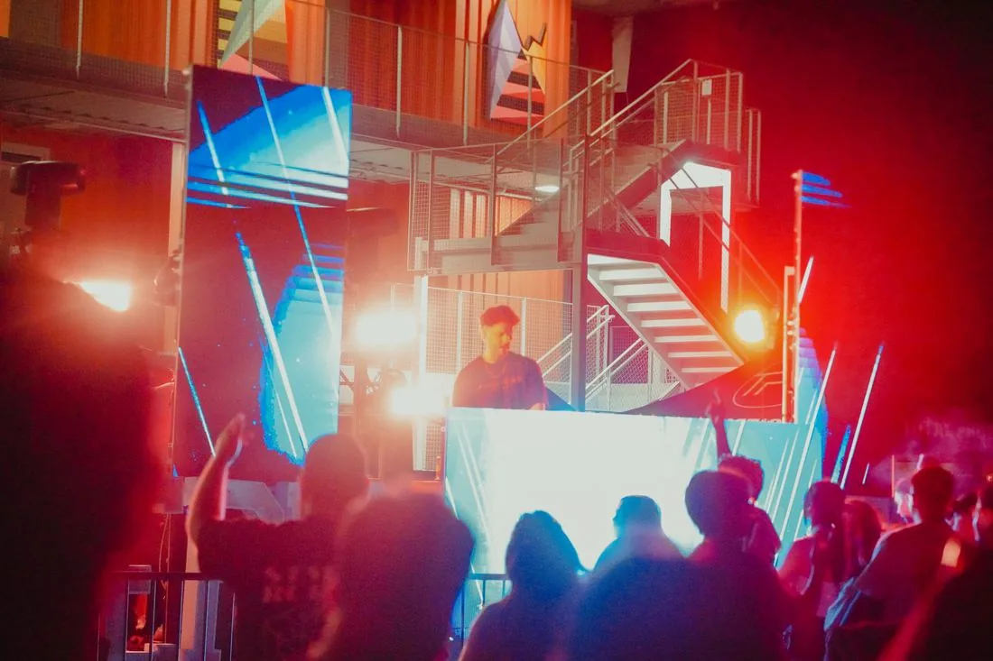 Crowd facing the stage under red and blue light