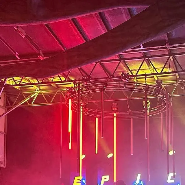 The EPIC stage at Waterfront Park lit red at night, EPIC spelled out in lights under the canopy