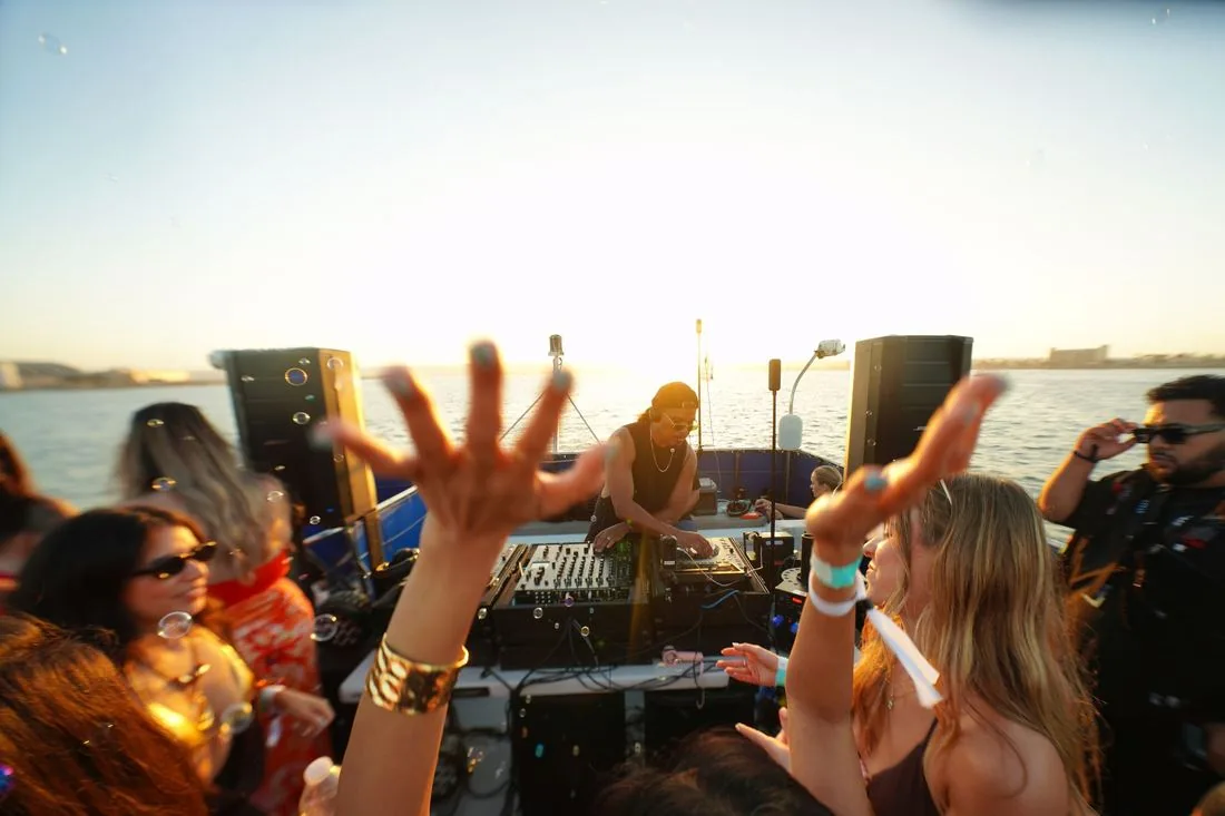 Hands up at sunset under a pale sky over the bay