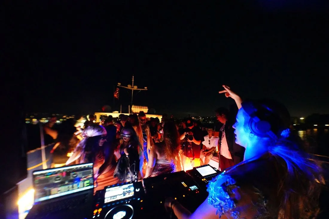 The booth from behind at night, blue light over the crowd